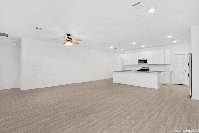 31908 Native Sun, Bulverde, TX 78163 - unfurnished living room featuring recessed lighting, light wood finished floors, a ceiling fan, and a sink