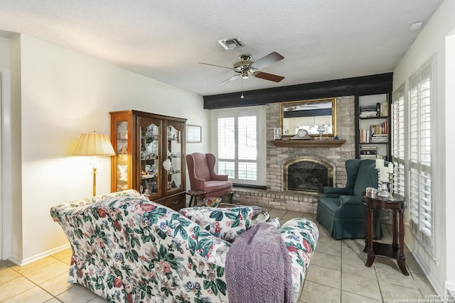 4722 Paradise Woods, San Antonio, TX 78249 - living area with tile patterned flooring, a ceiling fan, a fireplace, and a textured ceiling