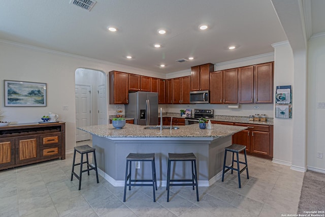 15166 Orpheus Way, San Antonio, TX 78245 - kitchen featuring appliances with stainless steel finishes, a sink, ornamental molding, a kitchen breakfast bar, and arched walkways