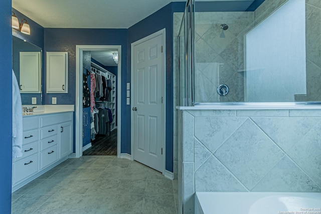 15166 Orpheus Way, San Antonio, TX 78245 - full bath with vanity, tiled shower, a spacious closet, and tile patterned floors