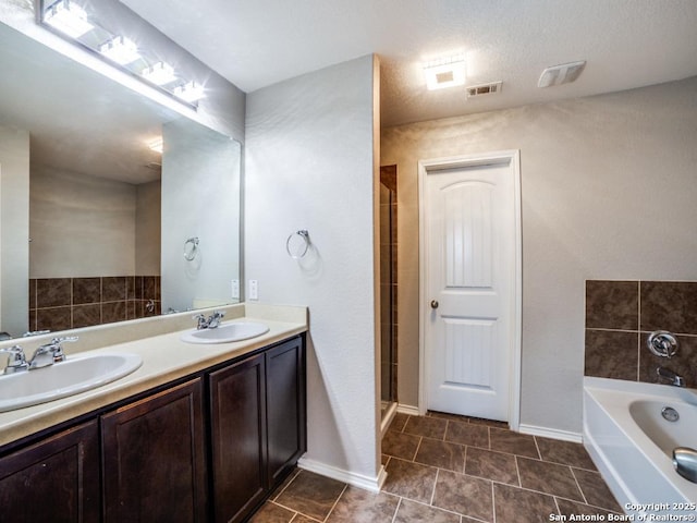 7010 Aphrodite Mist, San Antonio, TX 78252 - bathroom with a garden tub, double vanity, baseboards, a shower with door, and tile patterned floors