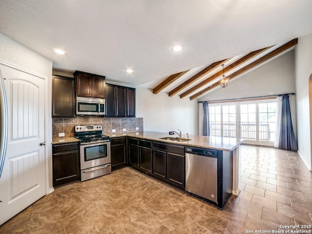 7010 Aphrodite Mist, San Antonio, TX 78252 - kitchen with appliances with stainless steel finishes, decorative backsplash, dark brown cabinetry, a sink, and a peninsula