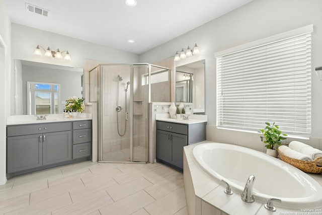 9304 Aggie Run, San Antonio, TX 78254 - full bathroom featuring a shower stall, a bath, two vanities, and recessed lighting