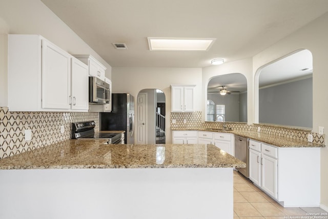 2606 Montebello, San Antonio, TX 78259 - kitchen with stainless steel appliances, a peninsula, a sink, arched walkways, and backsplash