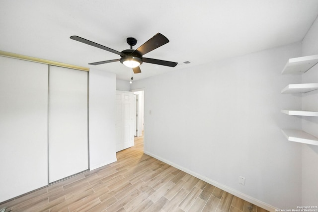 14201 Modesta Pl, San Antonio, TX 78247 - unfurnished bedroom featuring light wood-style floors, a closet, baseboards, and a ceiling fan
