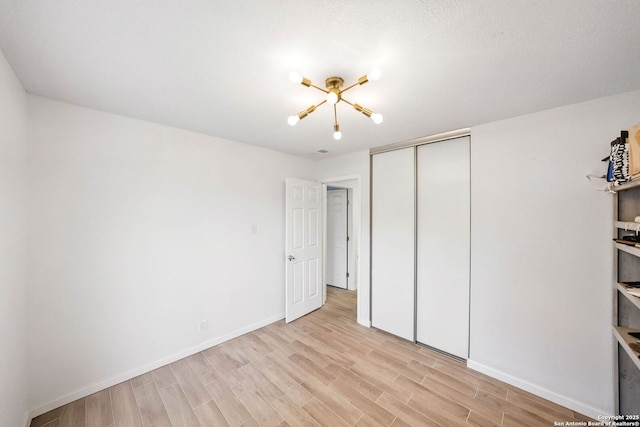 14201 Modesta Pl, San Antonio, TX 78247 - unfurnished bedroom with light wood finished floors, baseboards, and a closet