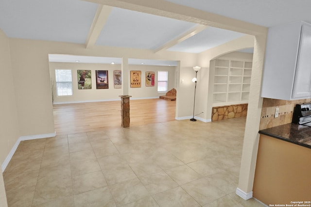 230 Tammy Dr, San Antonio, TX 78216 - unfurnished living room featuring beamed ceiling, baseboards, light tile patterned floors, and built in shelves