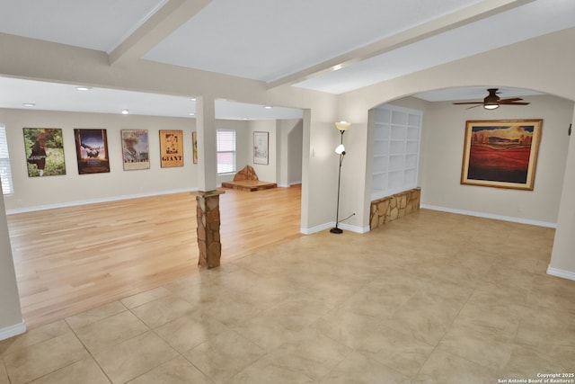 230 Tammy Dr, San Antonio, TX 78216 - unfurnished living room featuring ceiling fan, beamed ceiling, baseboards, arched walkways, and light wood-style flooring
