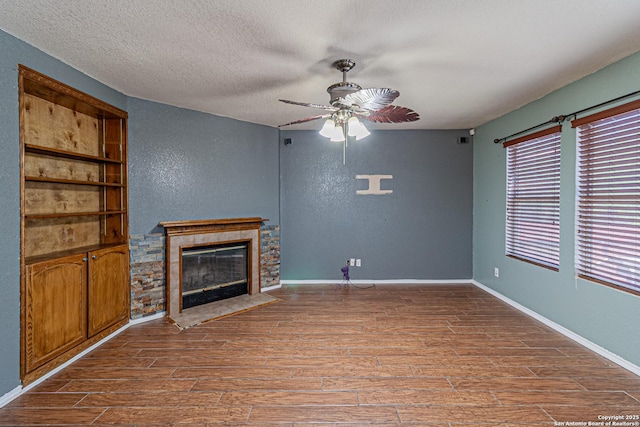 7202 Archers Coach, San Antonio, TX 78244 - unfurnished living room with ceiling fan, a textured ceiling, wood finished floors, a glass covered fireplace, and a textured wall
