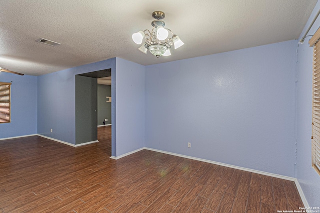 7202 Archers Coach, San Antonio, TX 78244 - unfurnished room featuring wood finished floors, a textured ceiling, baseboards, and a chandelier