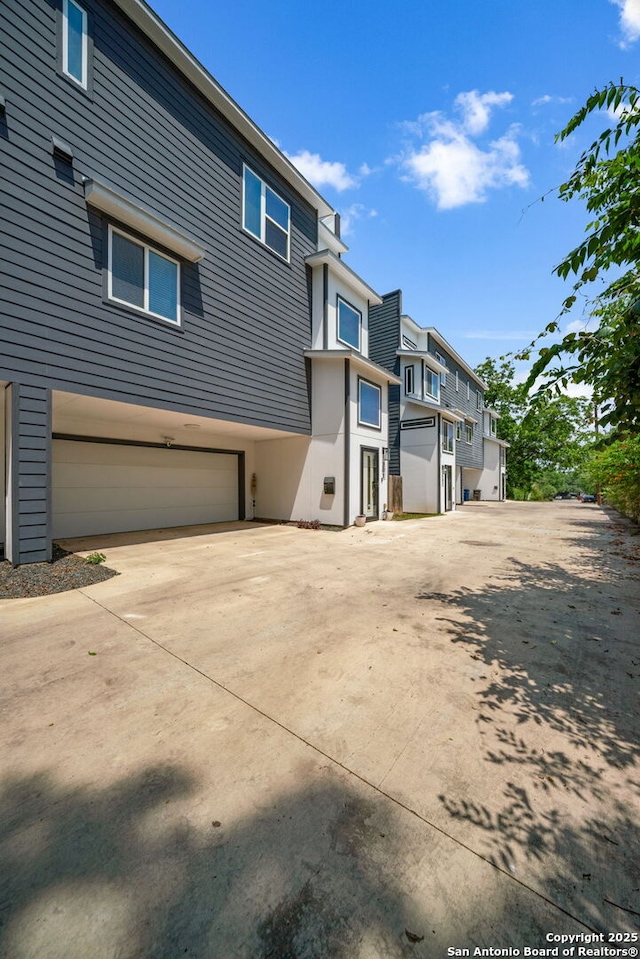 1226 Wyoming Unit 201, San Antonio, TX 78203 - back of property featuring a garage, concrete driveway, and a residential view