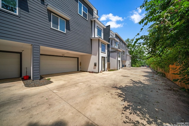 1226 Wyoming Unit 201, San Antonio, TX 78203 - view of side of property with driveway, an attached garage, and stucco siding