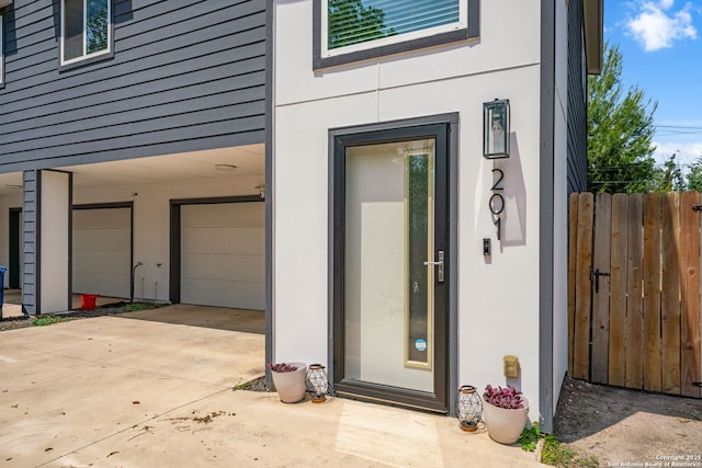 1226 Wyoming Unit 201, San Antonio, TX 78203 - doorway to property with an attached garage, concrete driveway, and stucco siding