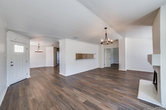 4335 Misty Spgs, San Antonio, TX 78244 - unfurnished living room featuring a chandelier, a fireplace with raised hearth, dark wood-type flooring, baseboards, and crown molding