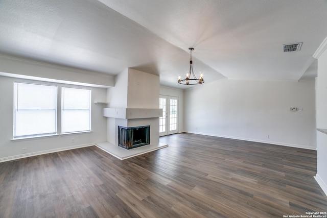 4335 Misty Spgs, San Antonio, TX 78244 - unfurnished living room with a chandelier, dark wood-style flooring, a fireplace with raised hearth, baseboards, and vaulted ceiling