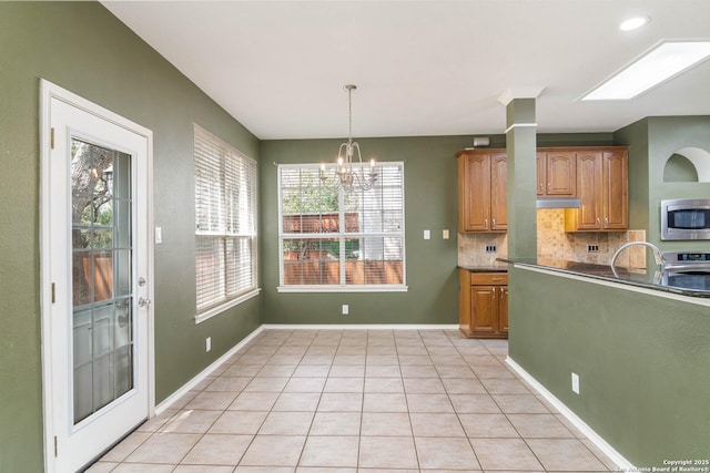 2610 Plum Holw, San Antonio, TX 78258 - kitchen featuring stainless steel appliances, a chandelier, tasteful backsplash, light tile patterned floors, and pendant lighting