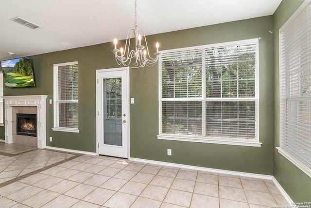 2610 Plum Holw, San Antonio, TX 78258 - unfurnished dining area with tile patterned flooring, a chandelier, baseboards, and a fireplace