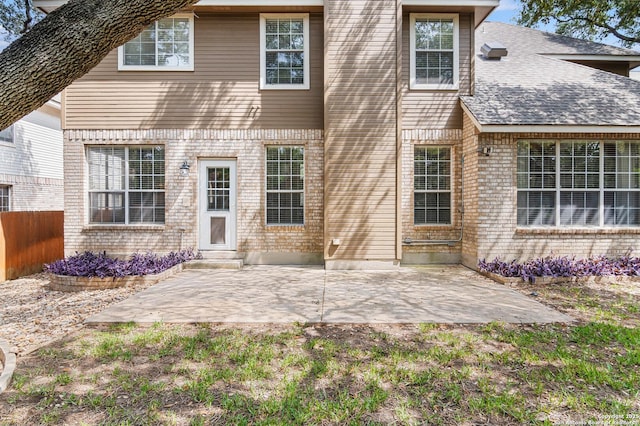 2610 Plum Holw, San Antonio, TX 78258 - rear view of property featuring brick siding, a patio area, and a shingled roof