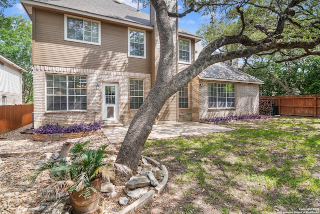 2610 Plum Holw, San Antonio, TX 78258 - back of house featuring brick siding, a fenced backyard, a patio area, roof with shingles, and entry steps