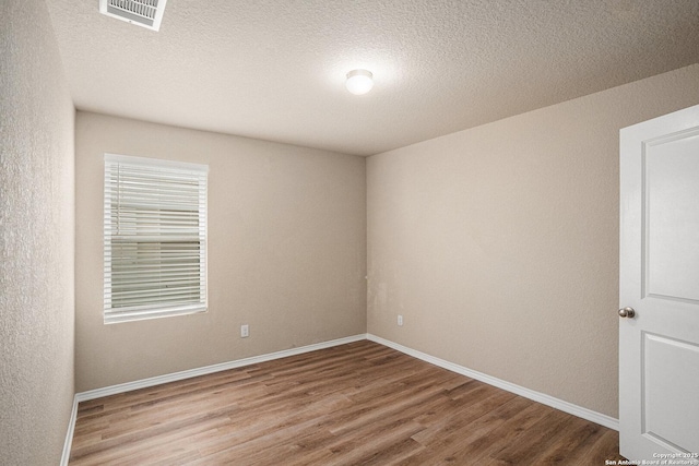 7406 Snapdragon Ct, Converse, TX 78109 - empty room with wood finished floors, baseboards, and a textured ceiling