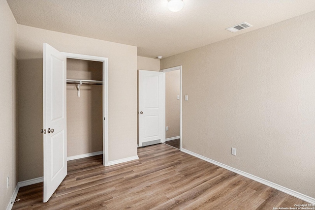 7406 Snapdragon Ct, Converse, TX 78109 - unfurnished bedroom with wood finished floors, a closet, and baseboards