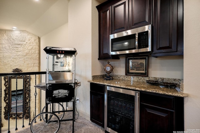 26019 Red Heron, San Antonio, TX 78261 - kitchen featuring wine cooler, stainless steel microwave, lofted ceiling, light stone counters, and dark brown cabinets
