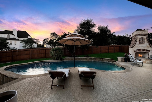 26019 Red Heron, San Antonio, TX 78261 - pool at dusk with a patio area, a fenced backyard, and an outdoor brick fireplace