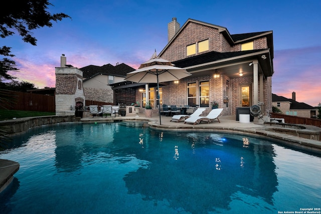 26019 Red Heron, San Antonio, TX 78261 - pool at dusk featuring a patio area and an outdoor living space with a fireplace