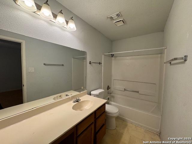 2854 Cherry Fld, San Antonio, TX 78245 - bathroom featuring toilet, vanity, tub / shower combination, and a textured ceiling