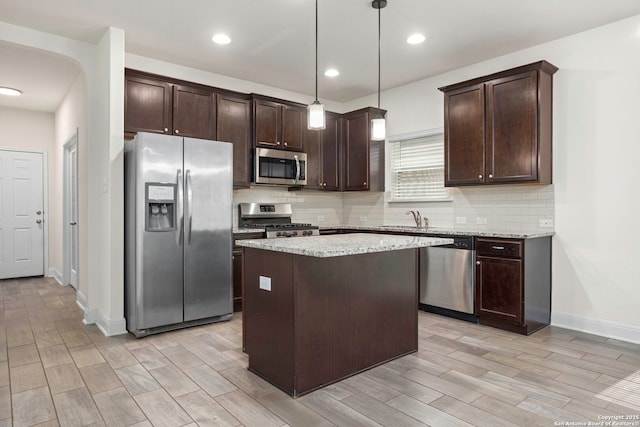 13106 Welder, San Antonio, TX 78253 - kitchen featuring appliances with stainless steel finishes, dark brown cabinetry, a sink, backsplash, and a center island