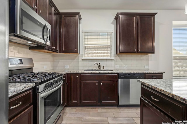 13106 Welder, San Antonio, TX 78253 - kitchen with stainless steel appliances, a sink, light stone counters, backsplash, and dark brown cabinetry