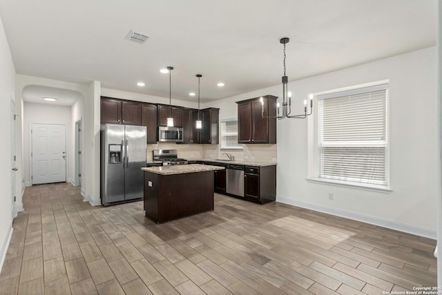 13106 Welder, San Antonio, TX 78253 - kitchen with stainless steel appliances, dark brown cabinets, light wood-style floors, a kitchen island, and recessed lighting