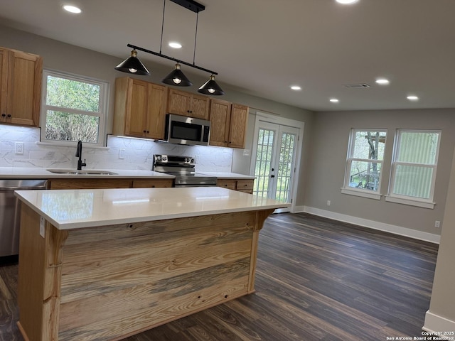 390 W Park St, Vidor, TX 77662 - kitchen featuring stainless steel appliances, a sink, dark wood finished floors, baseboards, and light countertops
