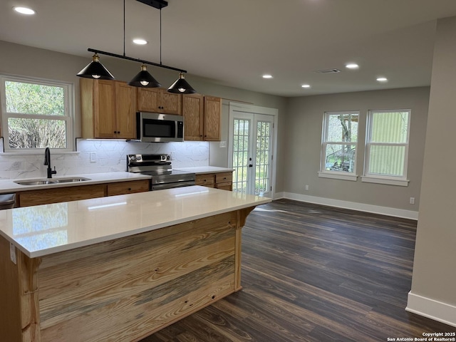 390 W Park St, Vidor, TX 77662 - kitchen featuring stainless steel appliances, a sink, brown cabinetry, baseboards, and recessed lighting