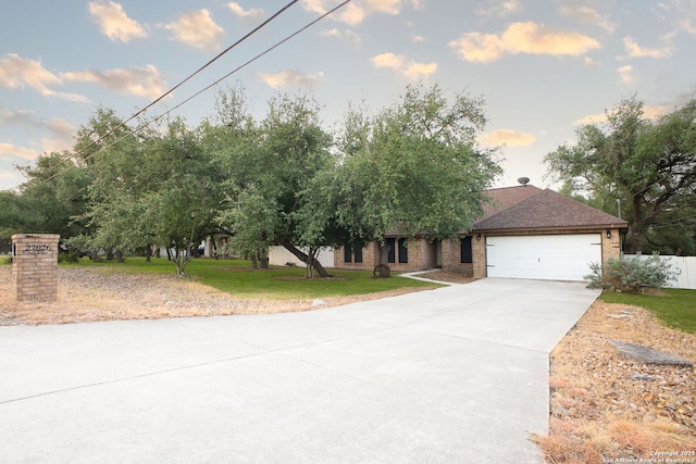 27026 Wooded Acres, San Antonio, TX 78260 - obstructed view of property with concrete driveway, an attached garage, a front yard, and brick siding