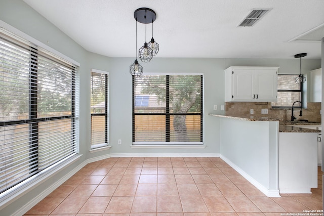 27026 Wooded Acres, San Antonio, TX 78260 - unfurnished dining area with plenty of natural light, a sink, light tile patterned floors, and baseboards