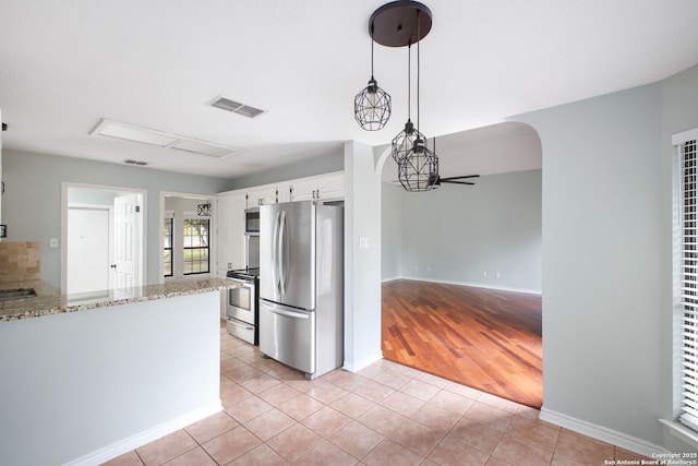 27026 Wooded Acres, San Antonio, TX 78260 - kitchen with appliances with stainless steel finishes, white cabinets, light stone countertops, light tile patterned floors, and baseboards