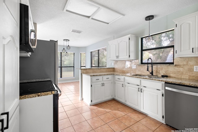 27026 Wooded Acres, San Antonio, TX 78260 - kitchen with stainless steel appliances, a sink, a peninsula, a textured ceiling, and white cabinetry