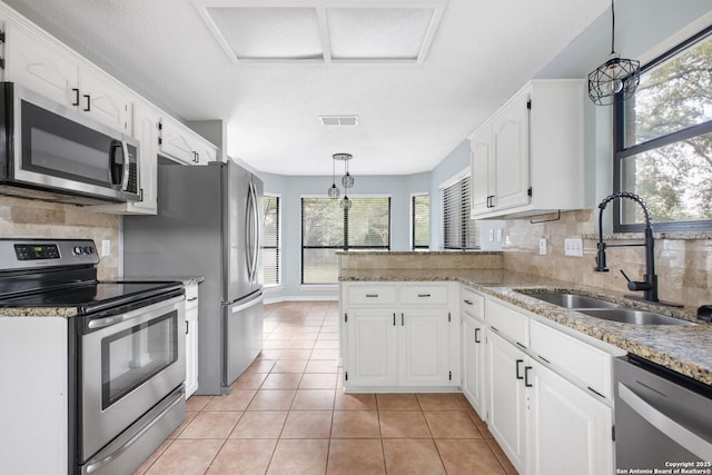 27026 Wooded Acres, San Antonio, TX 78260 - kitchen with appliances with stainless steel finishes, a sink, a peninsula, tasteful backsplash, and white cabinets