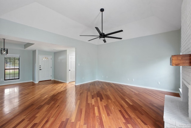 27026 Wooded Acres, San Antonio, TX 78260 - unfurnished living room with a brick fireplace, a ceiling fan, wood finished floors, and baseboards