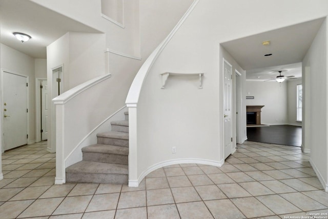 522 Mesa Rdg, San Antonio, TX 78258 - entrance foyer featuring light tile patterned flooring, ceiling fan, stairway, baseboards, and a fireplace