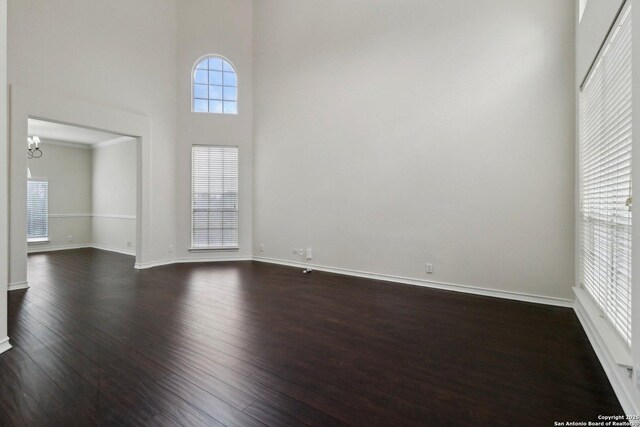 522 Mesa Rdg, San Antonio, TX 78258 - spare room featuring dark wood-type flooring, a chandelier, a towering ceiling, and baseboards