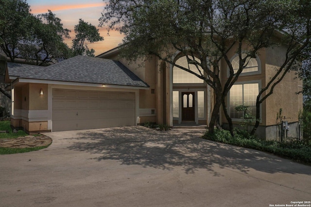 522 Mesa Rdg, San Antonio, TX 78258 - view of front of home featuring driveway, stucco siding, a garage, and a shingled roof