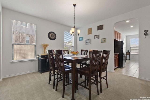 15239 Sirius Cir, San Antonio, TX 78245 - dining area featuring arched walkways, light carpet, healthy amount of natural light, and a chandelier
