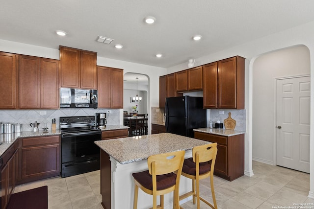 15239 Sirius Cir, San Antonio, TX 78245 - kitchen featuring black appliances, arched walkways, decorative backsplash, light stone countertops, and recessed lighting