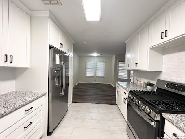 258 Galway, San Antonio, TX 78223 - kitchen featuring stainless steel appliances, white cabinetry, tasteful backsplash, and light stone countertops