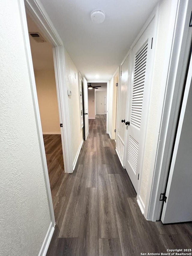 258 Galway, San Antonio, TX 78223 - hall with dark wood-style floors, a textured wall, and baseboards