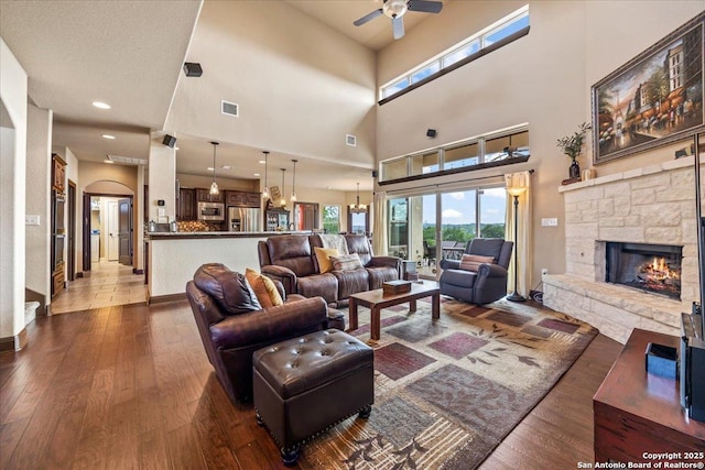406 Breathless View St, San Antonio, TX 78260 - living room with a ceiling fan, dark wood-style floors, a stone fireplace, a high ceiling, and baseboards