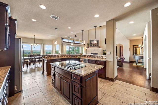 406 Breathless View St, San Antonio, TX 78260 - kitchen featuring appliances with stainless steel finishes, a chandelier, vaulted ceiling, backsplash, and arched walkways