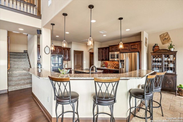 406 Breathless View St, San Antonio, TX 78260 - kitchen with stainless steel appliances, light stone counters, baseboards, a kitchen breakfast bar, and decorative backsplash